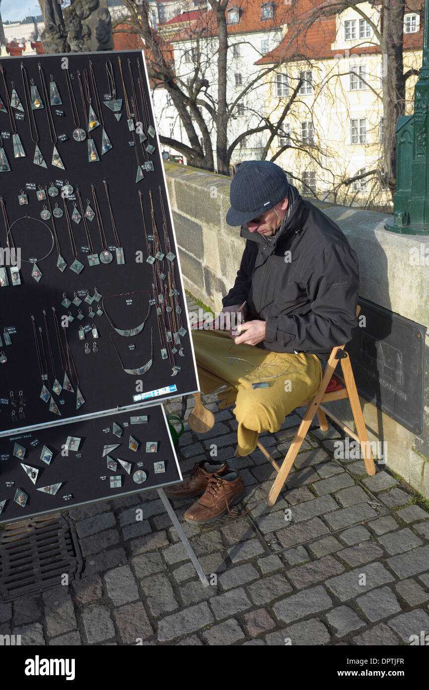 Jewelery venditore sul Ponte Carlo si trova in posizione di yoga a lavorare al suo mestiere Foto Stock