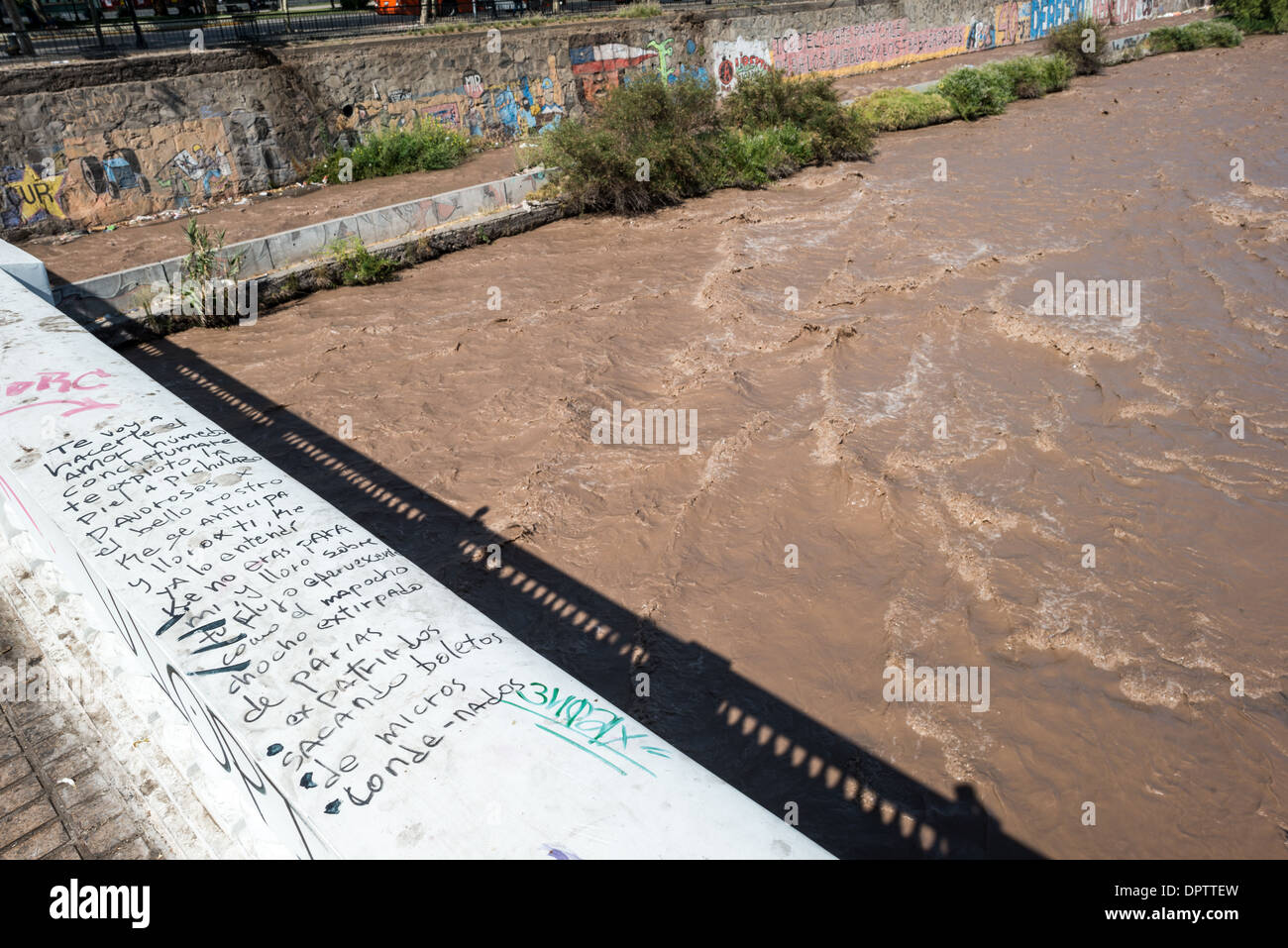 Mapocho River Santiago Cile // SANTIAGO, Cile - il fiume Mapocho attraversa il cuore di Santiago, capitale del Cile, dividendo effettivamente il paesaggio urbano in sezioni settentrionali e meridionali. Originatosi nelle Ande, il fiume è uno dei principali corsi d'acqua del bacino di Santiago. Il Mapocho ha svolto un ruolo significativo nello sviluppo della città sin dalla sua fondazione nel 1541, funzionando sia come confine naturale che come fonte d'acqua vitale. Oggi, il fiume è fiancheggiato da parchi e infrastrutture urbane, tra cui il Parque Forestal che corre lungo porzioni del suo b Foto Stock
