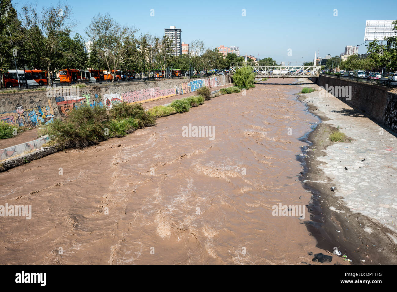 Mapocho River Urban Landscape Santiago Cile // SANTIAGO, Cile - il fiume Mapocho attraversa il cuore di Santiago, capitale del Cile, dividendo effettivamente il paesaggio urbano in sezioni settentrionali e meridionali. Originatosi nelle Ande, il fiume è uno dei principali corsi d'acqua del bacino di Santiago. Il Mapocho ha svolto un ruolo significativo nello sviluppo della città sin dalla sua fondazione nel 1541, funzionando sia come confine naturale che come fonte d'acqua vitale. Oggi, il fiume è fiancheggiato da parchi e infrastrutture urbane, tra cui il Parque Forestal che costeggia il fiume Foto Stock