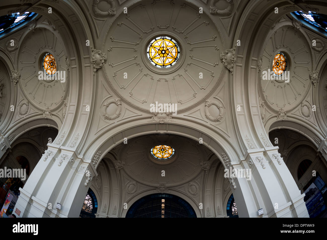 Estacion Mapocho Dome in vetro colorato Santiago Cile // SANTIAGO, Cile - il tetto a cupola ornato di Estacion Mapocho presenta squisiti elementi in vetro colorato che mostrano la grandezza architettonica e il significato storico dell'edificio. Costruita nel 1912, questa ex stazione ferroviaria fungeva da principale nodo di trasporto di Santiago prima di essere trasformata in un centro culturale. La cupola meticolosamente restaurata esemplifica lo stile architettonico Beaux-Arts popolare durante lo sviluppo cileno dell'inizio del XX secolo. Oggi, Estacion Mapocho funge da importante centro per convegni e concerti pubblici, h Foto Stock