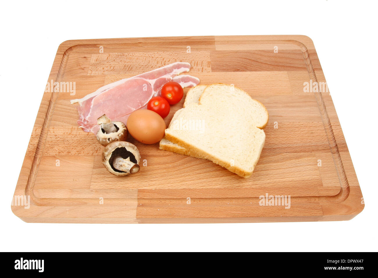 La colazione ingredienti su di un legno di faggio preparazione alimentare board isolata contro bianco Foto Stock