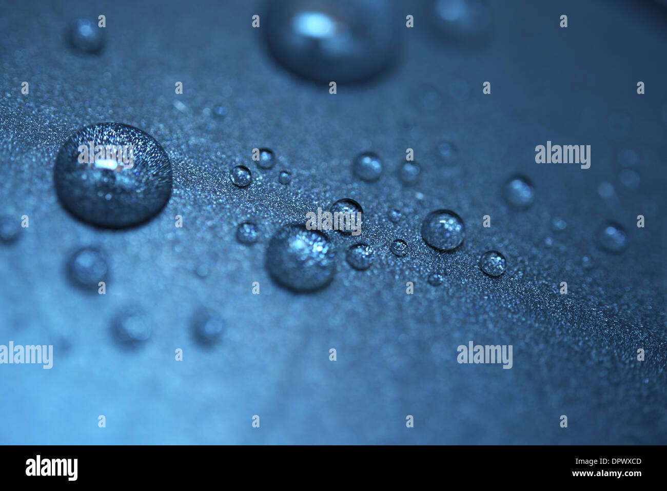 Gocce di pioggia ob materiale bluastra dello sfondo. Foto Stock
