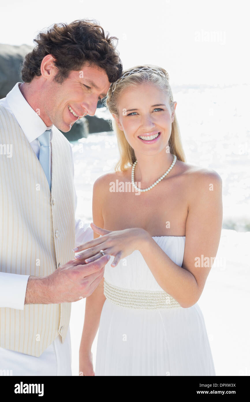 Uomo bello posizionando l'anello sul happy brides dito Foto Stock