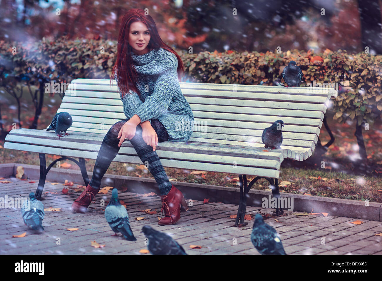 Giovane donna in park seduta sul banco di lavoro. Foto Stock