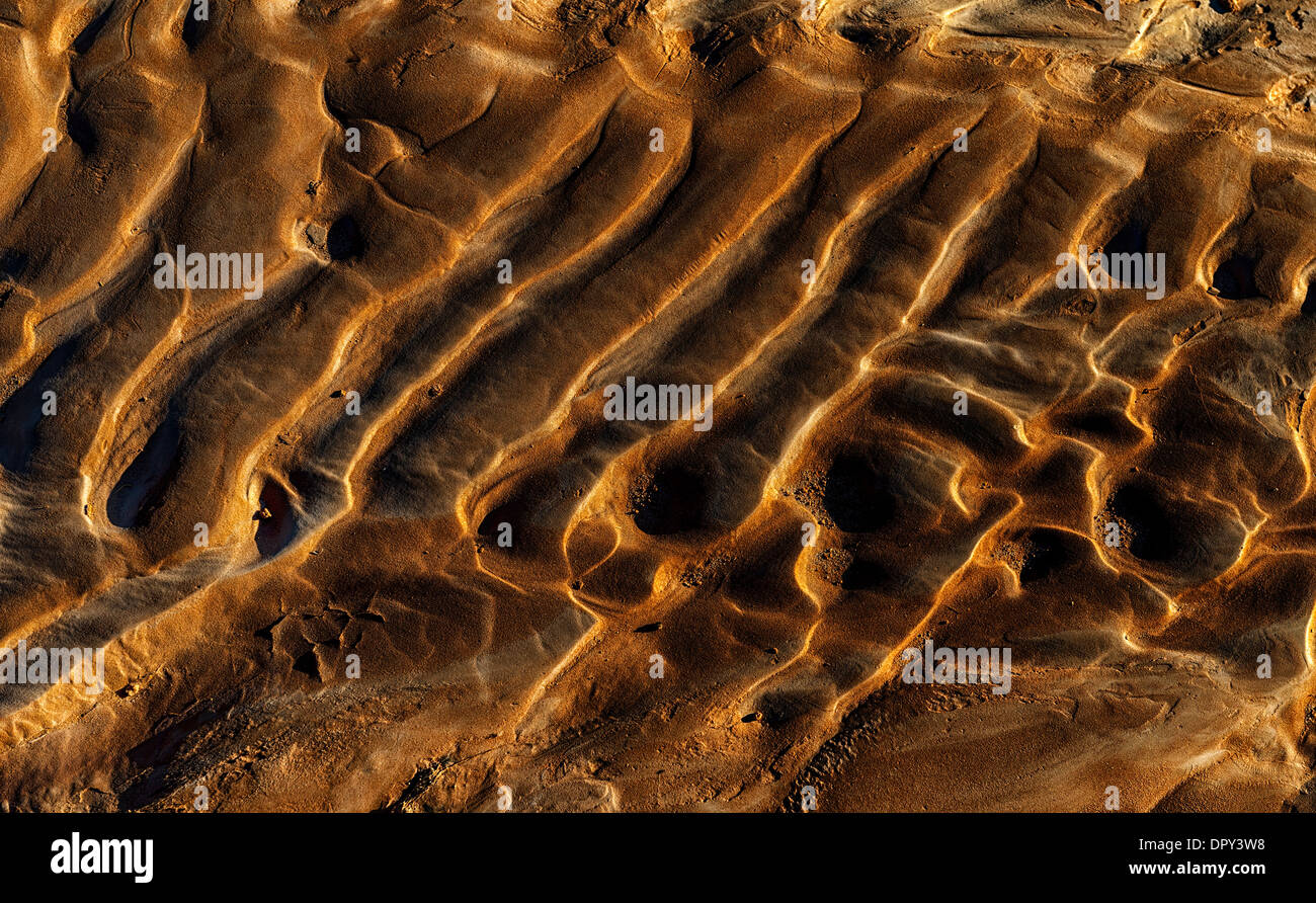 Ripples formato da acqua e nel tardo pomeriggio sun.caldi colori oro marrone e toni di rosso. Per usare come sfondo e arte applicazioni. Foto Stock