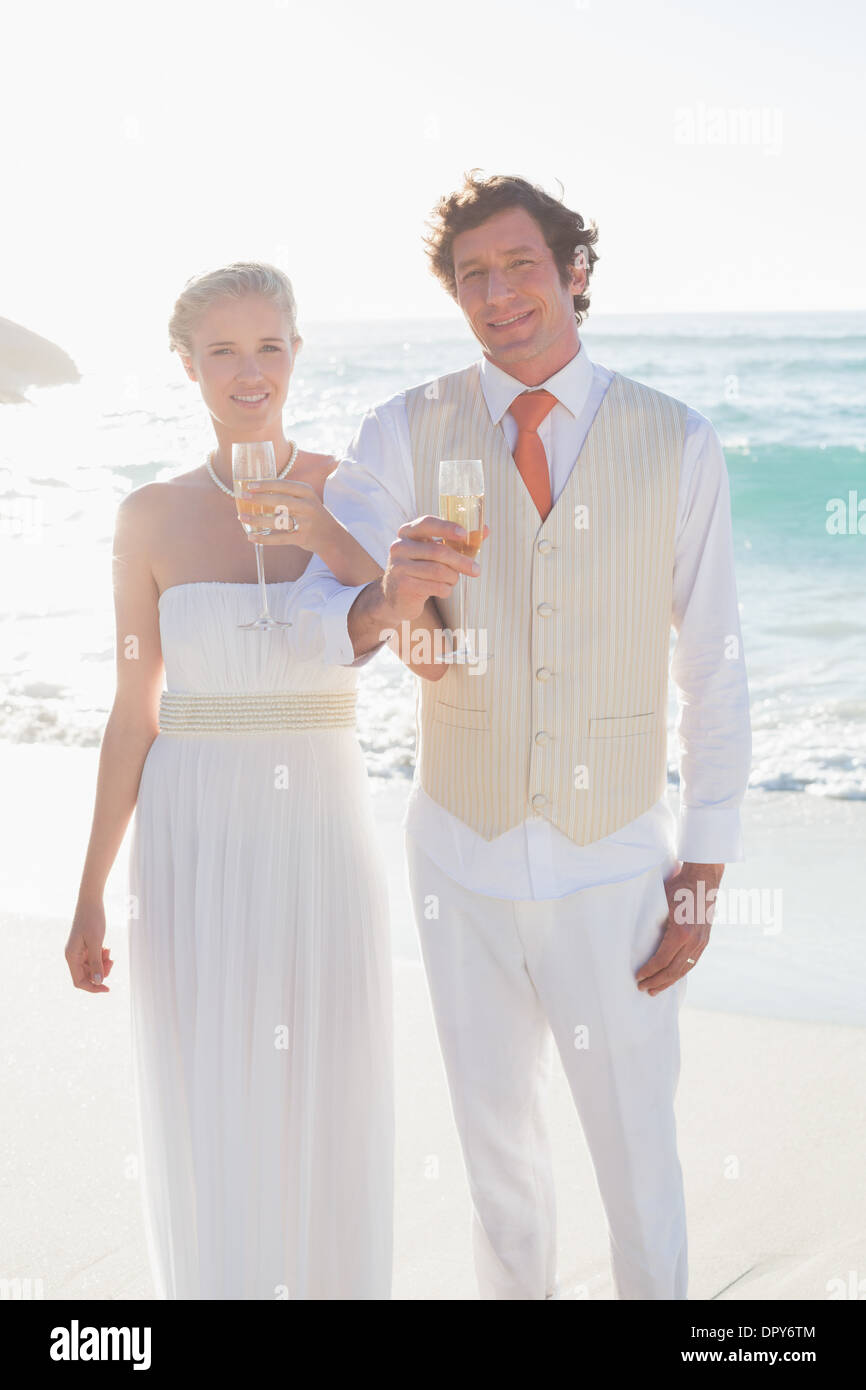 Happy sposi champagne avente bracci di collegamento Foto Stock