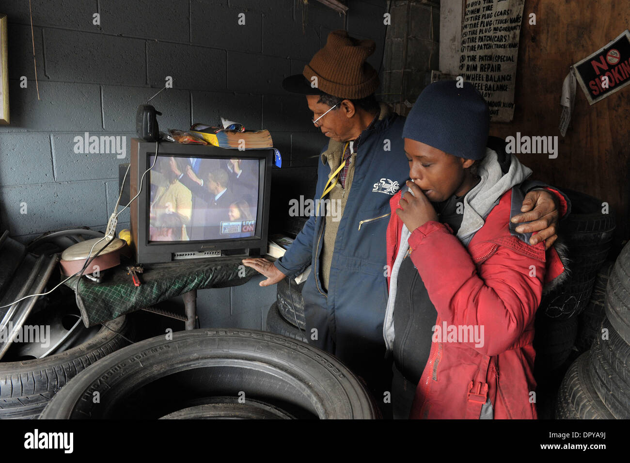 Jan 20, 2009 - Atlanta, Georgia, Stati Uniti d'America - JAMES AGAZIE, 66, un nigeriano-nato naturalizzato cittadino americano, orologi cerimonie inaugurali in televisione con la sua nuora AGAZIE ROCHELE nella loro piccola riparazione pneumatici garage. "Io sono così orgoglioso di essere un americano, ma io non ho mai pensato di vivere per vedere questo giorno," dice il Sig. Agazie. (Credito Immagine: © Robin Nelson/ZUMA Press) Foto Stock