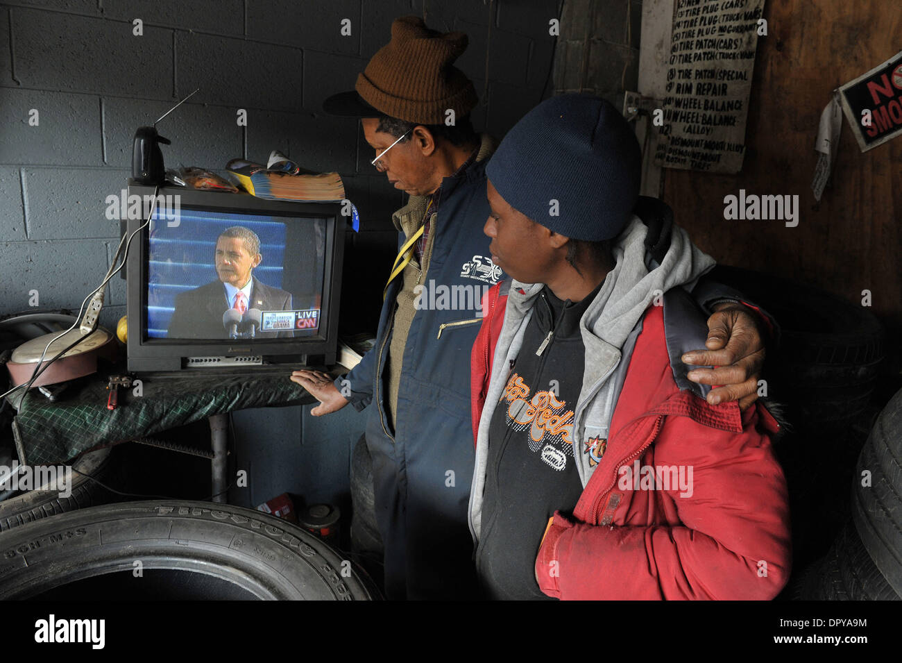 Jan 20, 2009 - Atlanta, Georgia, Stati Uniti d'America - JAMES AGAZIE, 66, un nigeriano-nato naturalizzato cittadino americano, orologi cerimonie inaugurali in televisione con la sua nuora AGAZIE ROCHELE nella loro piccola riparazione pneumatici garage. "Io sono così orgoglioso di essere un americano, ma io non ho mai pensato di vivere per vedere questo giorno," dice il Sig. Agazie. (Credito Immagine: © Robin Nelson/ZUMA Press) Foto Stock