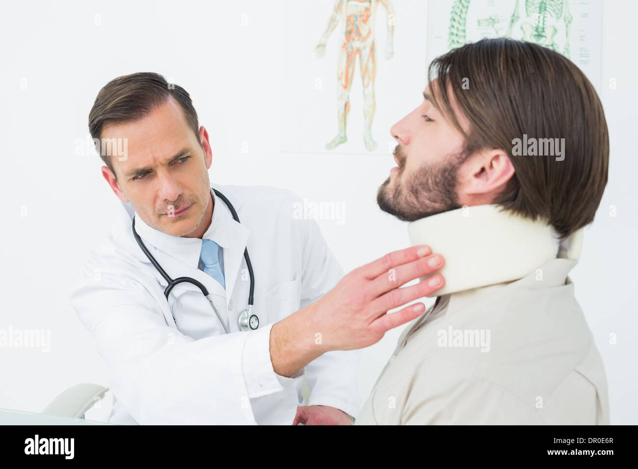 Medico maschio esaminando un collo del paziente Foto Stock