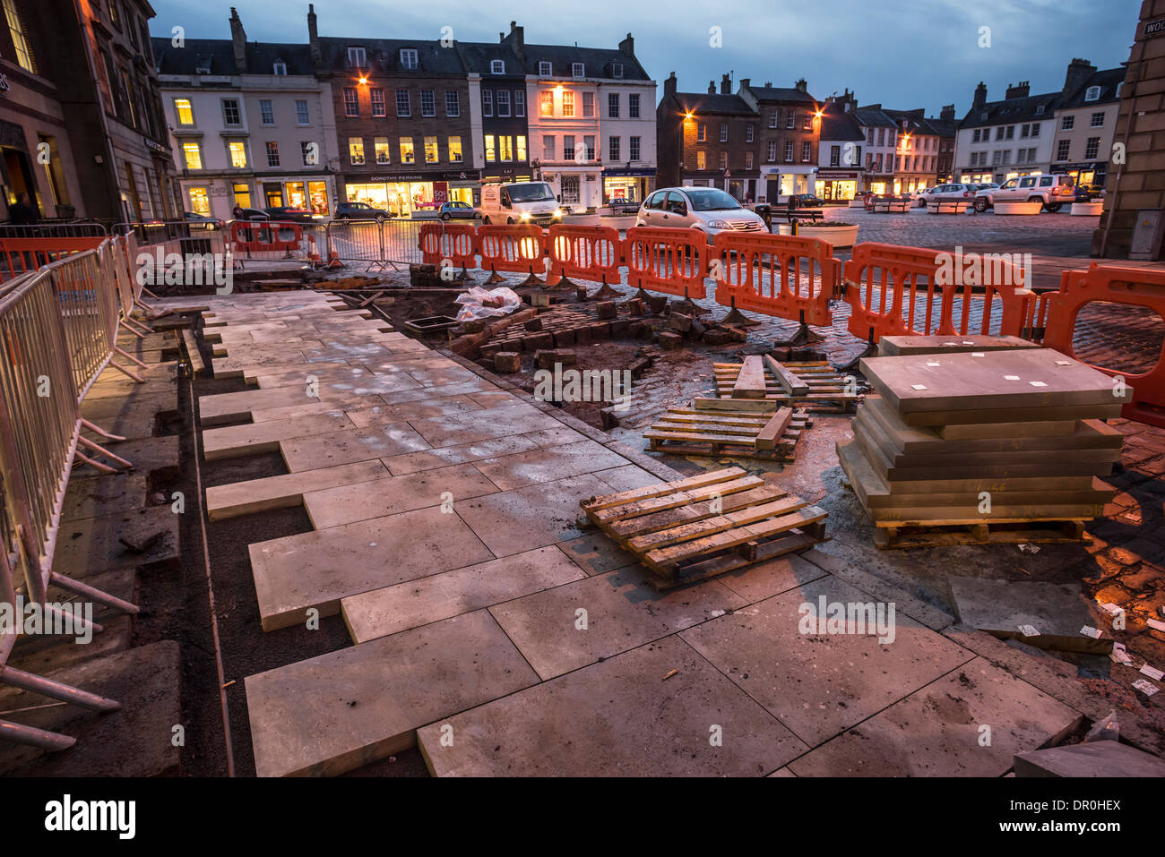 Marshalls plc marciapiede in lastre per pavimentazione parzialmente adagiato nel centro della città di riconversione a Kelso, Scozia; il lavoro si ferma per la notte. Foto Stock