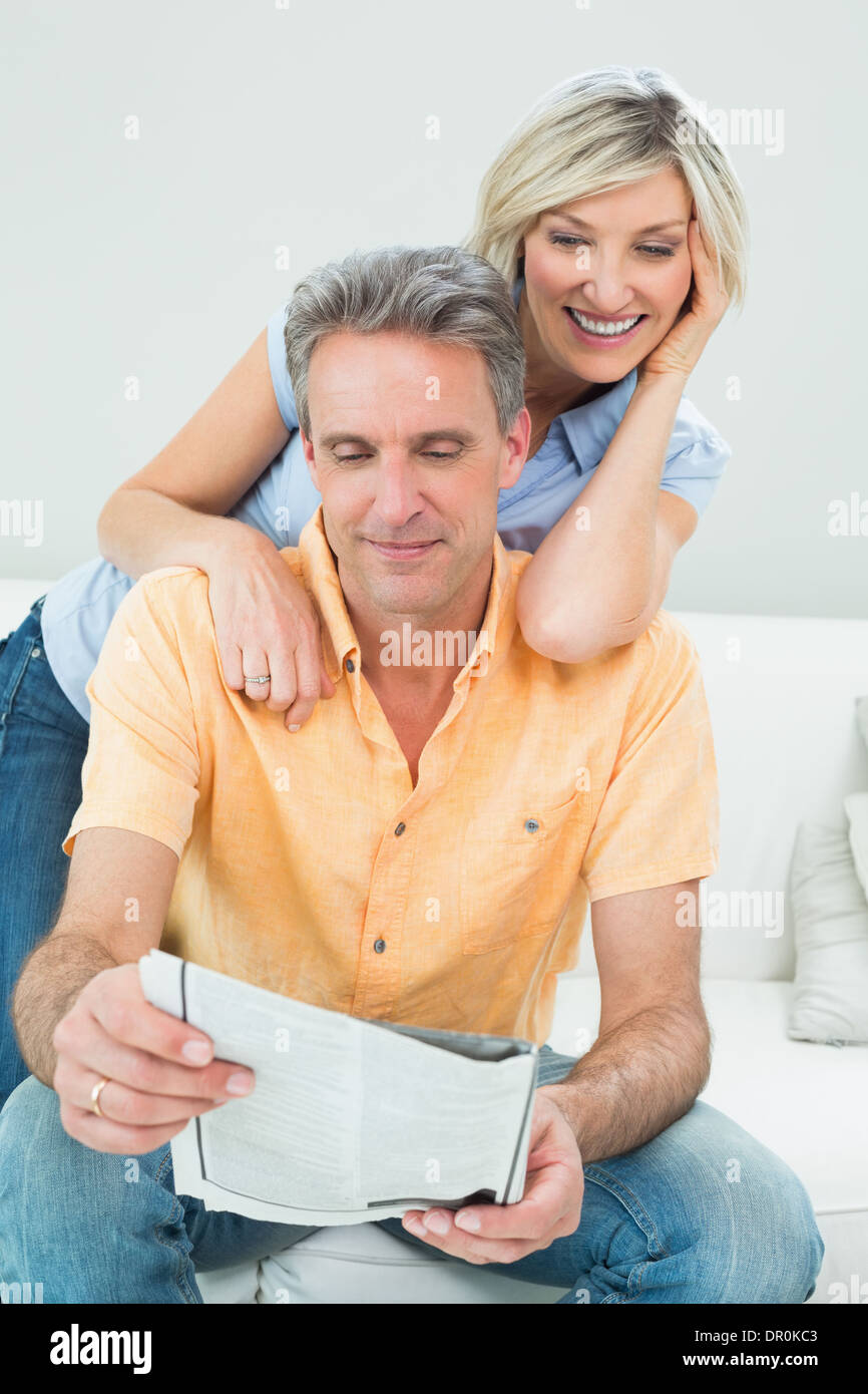 Coppia felice leggendo il giornale in soggiorno Foto Stock