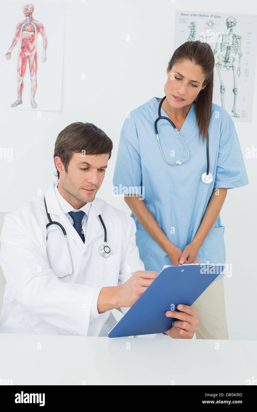 I medici a discutere i report in un ufficio medico Foto Stock
