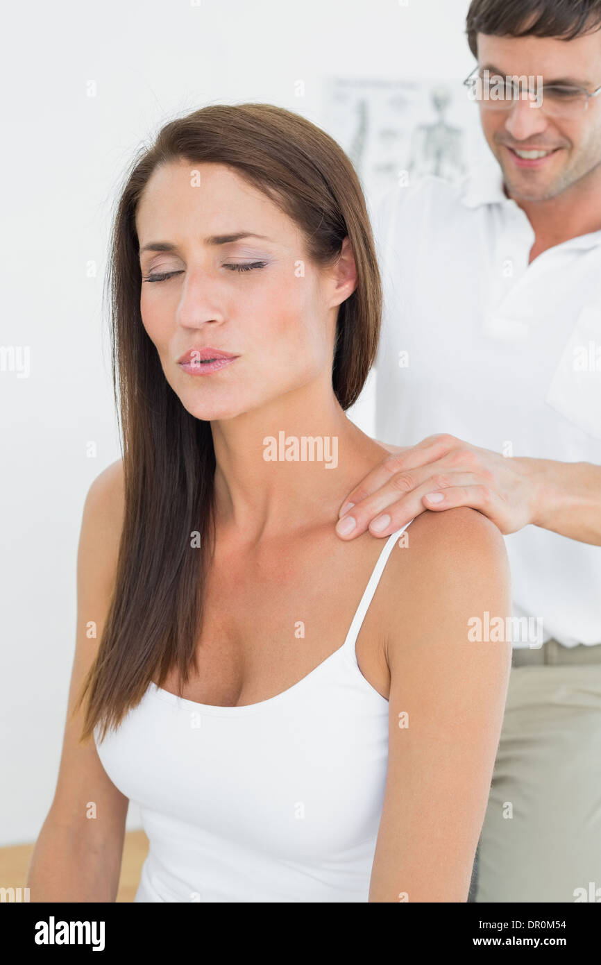 Maschio di massaggio chiropratico di una giovane donna di spallamento Foto Stock