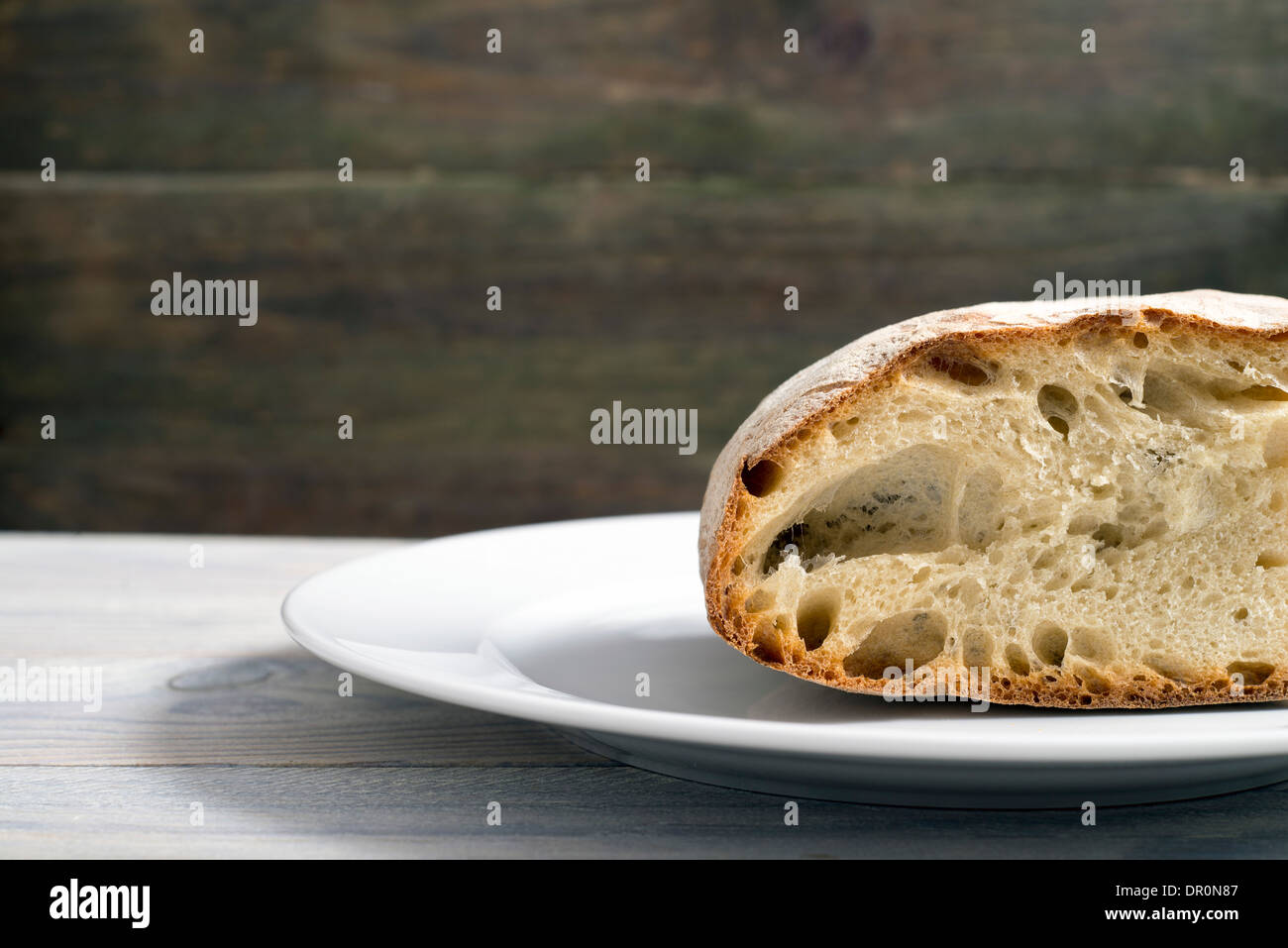 Filone di pane su un rustico sfondo di legno Foto Stock