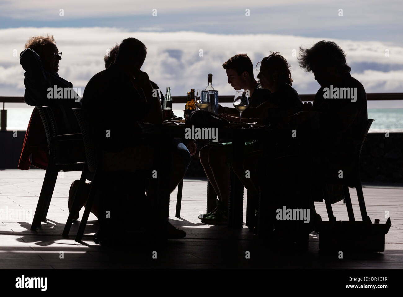 Silhouette di un gruppo di persone di mangiare il pranzo in un ambiente all'aperto a Fuencaliente, La Palma, Isole Canarie, Spagna. Foto Stock