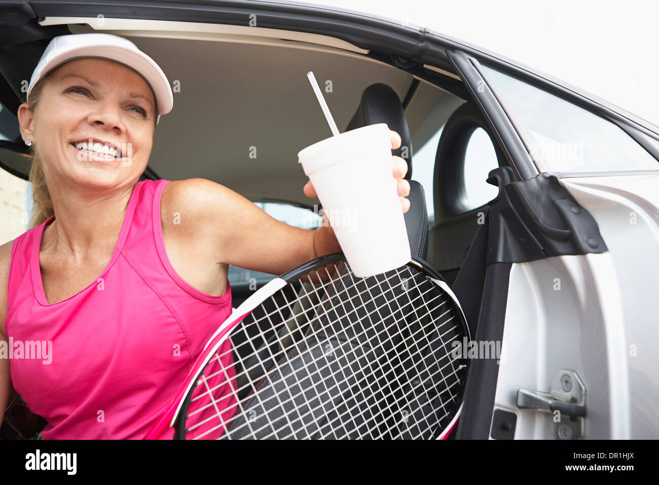 Caucasian giocatore di tennis arrampicata al di fuori della vettura Foto Stock