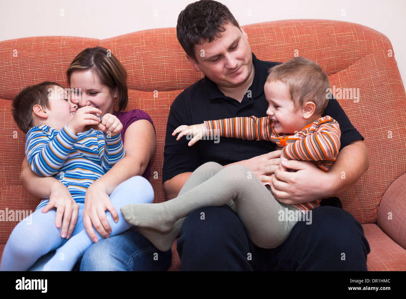 Felice i genitori con bambini che si divertono a casa Foto Stock