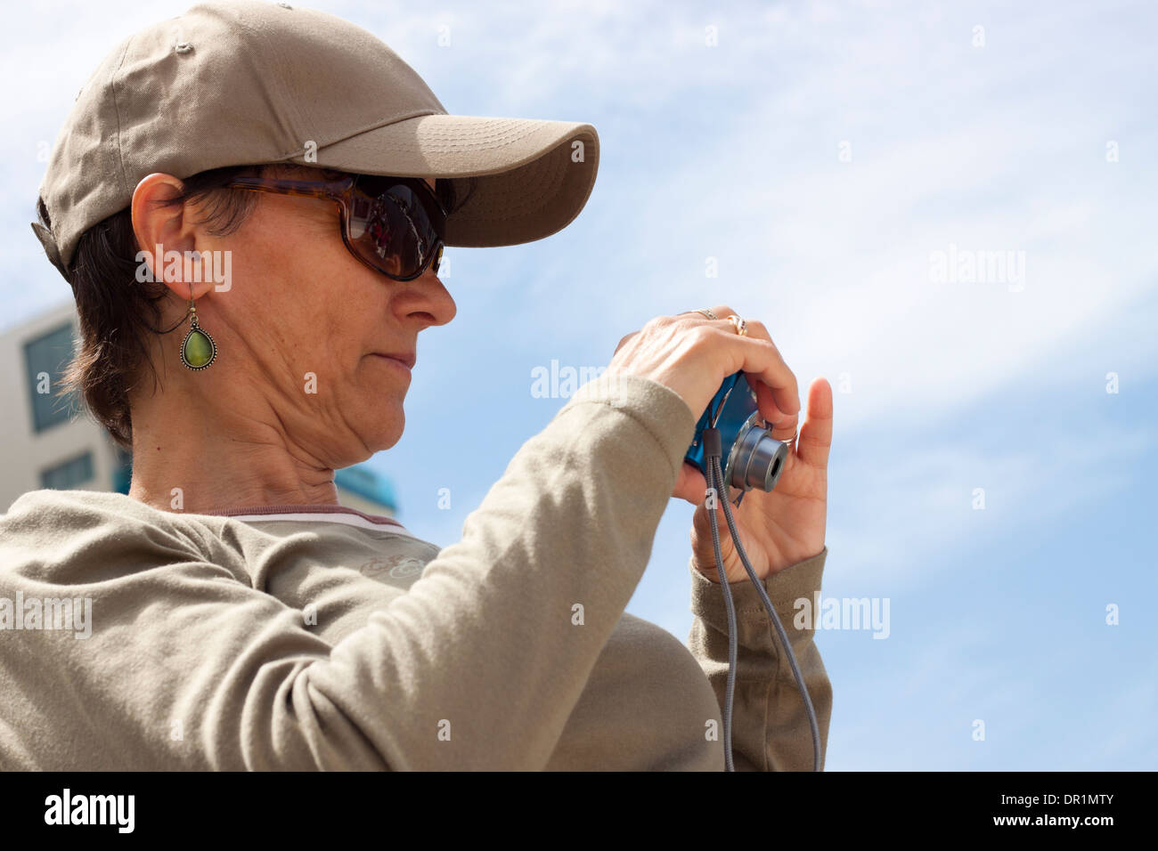 Donna di mezza età per scattare delle foto utilizzando la fotocamera compatta. Foto Stock