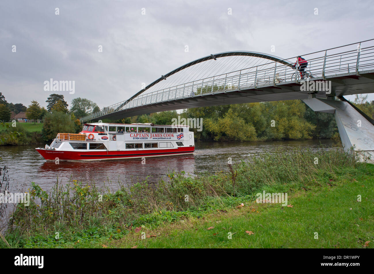 I passeggeri possono usufruire di viaggio navigando sul fiume Ouse a bordo di piccole imbarcazioni di crociera, passando sotto il Ponte del Millennio come ciclista attraversa overhead - York, Inghilterra, Regno Unito. Foto Stock