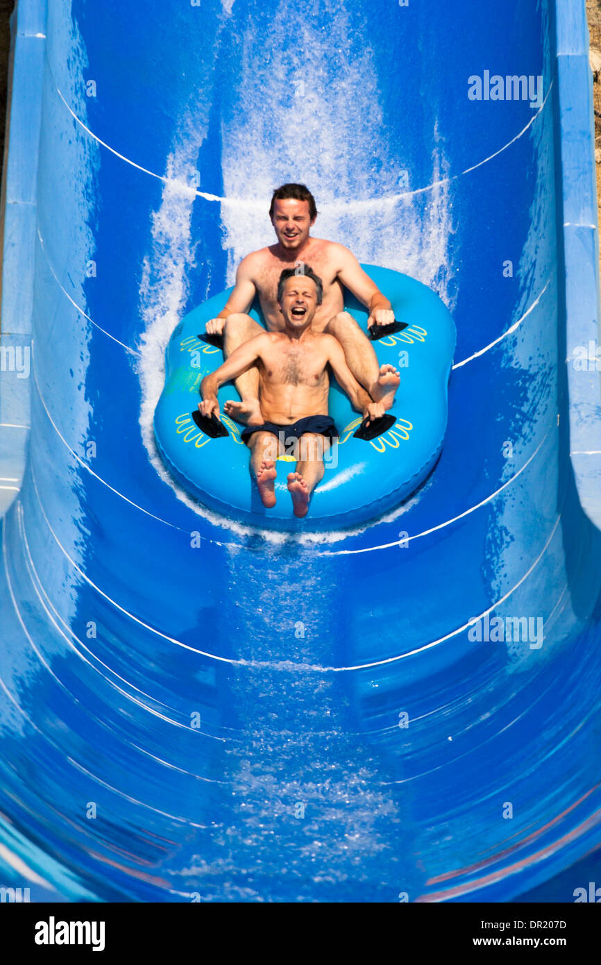 Due uomini si diverte, persone scorrere acqua a Aqua park. Foto Stock