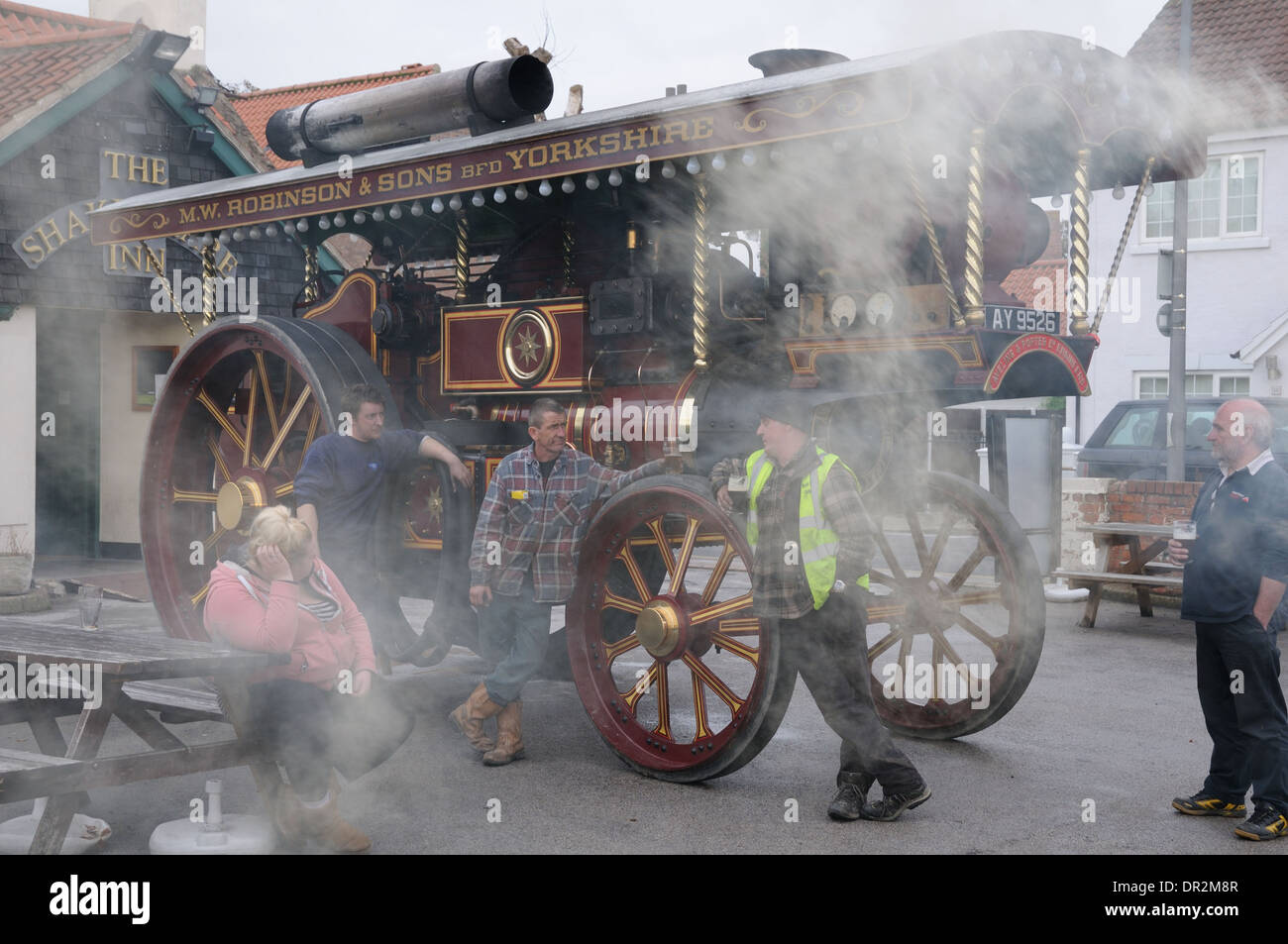 Gli appassionati di vapore in piedi accanto a un Aveling e Porter con trazione a vapore motore sono avvolte in una nuvola di fumo, Troon, East Yorkshire, Inghilterra Foto Stock