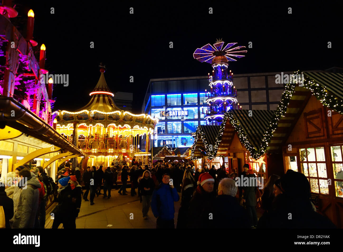 Berlino, Germania - 21 dicembre 2013: Serata shoppers godendo il mercato di Natale e il parco di divertimenti in Alexanderplatz di Berlino. Foto Stock