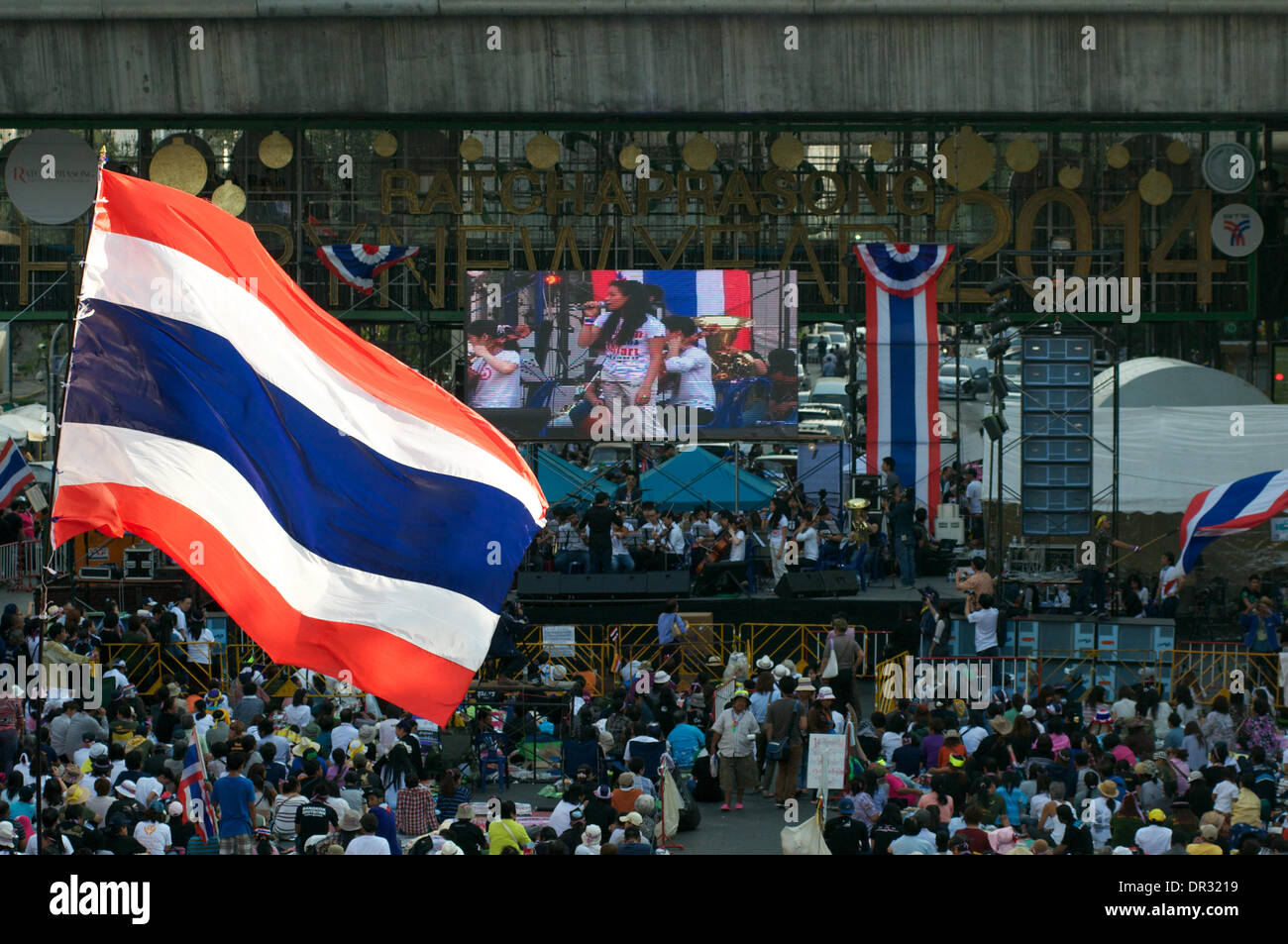 Bangkok, Tailandia. Gennaio 18th, 2014. Migliaia di anti-contestatori del governo tailandese di onda di bandiere e di bloccare la Ratchaprasong incrocio nel centro cittadino di Bangkok. Dopo un micidiale attentato al venerdì a Bangkok, decine di migliaia di manifestanti sono scesi in piazza per chiedere le dimissioni del Primo ministro tailandese Yingluck Shinawatra. 'Shutdown Bangkok' è organizzato dal popolo della riforma democratica Comitato (PDRC). Credito: Kraig Lieb / Alamy Live News Foto Stock