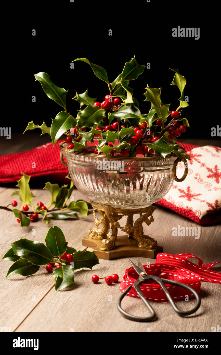 Decorazione per il Natale con antichi vaso pieno di agrifoglio e bacche Foto Stock