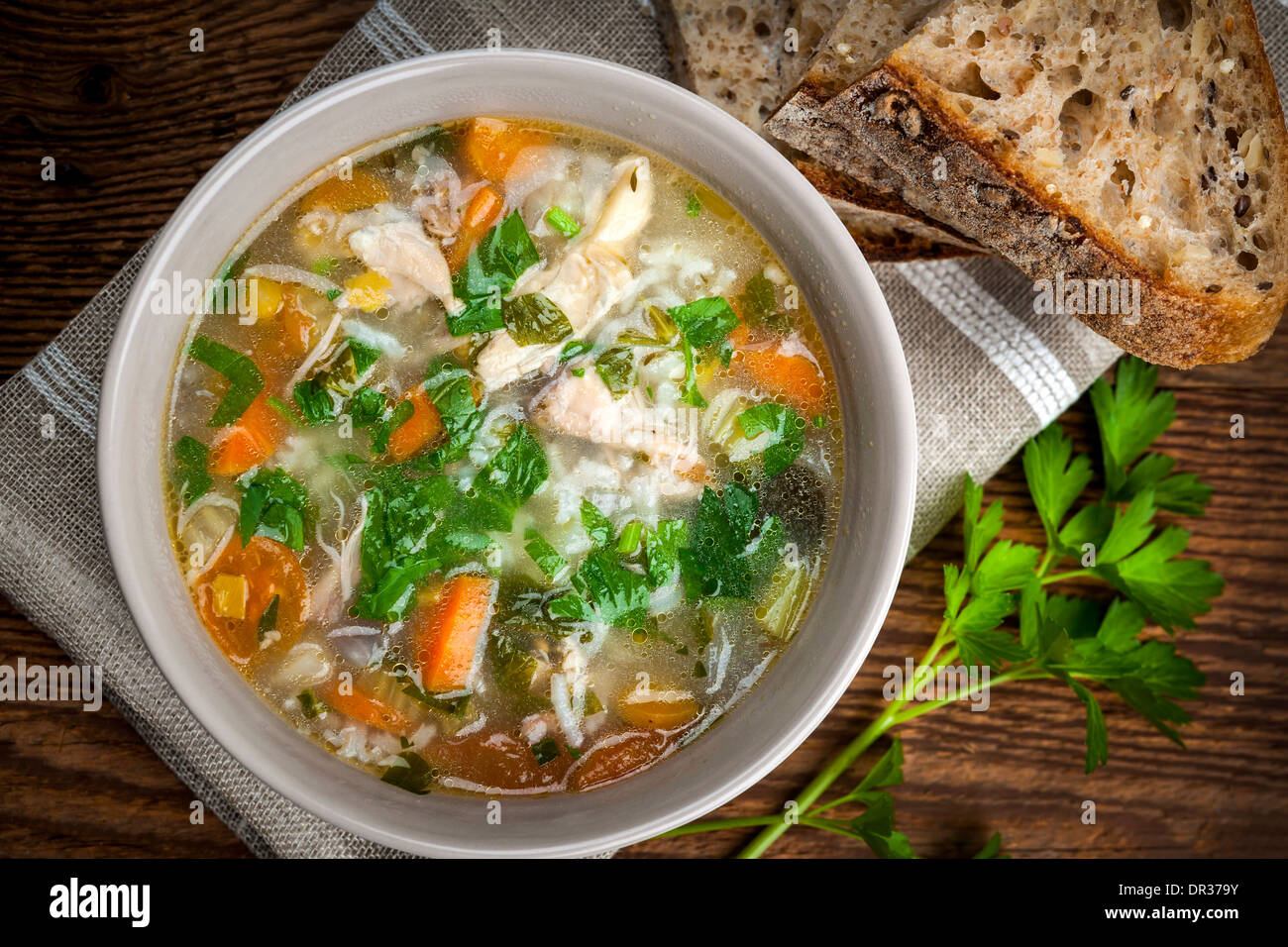 Pollo zuppa di riso con le verdure in una terrina e pane da sopra Foto Stock