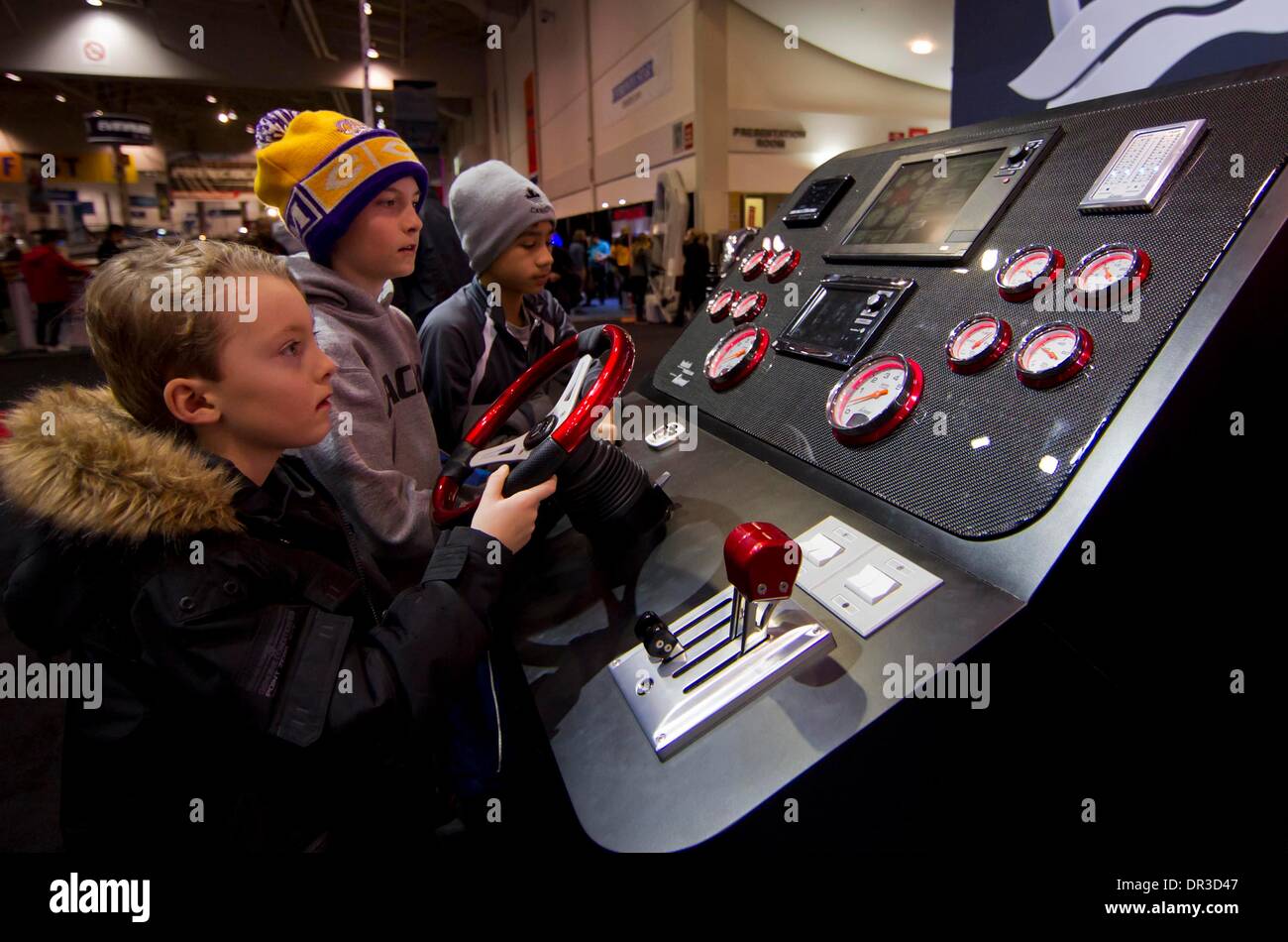 Toronto, Canada. Xix gen, 2014. Kids provare la guida di un pannello di controllo sul display durante il 2014 Toronto International Boat Show a energia diretta centro di Exhibition Place a Toronto, Canada, Gennaio 18, 2014. Come uno dei più grandi consumatori barca mostra in Nord America e in questo caso espone più di mille i nuovi modelli di imbarcazioni e motori sul mercato da Gen 11 al 19 gen. Credito: Zou Zheng/Xinhua/Alamy Live News Foto Stock