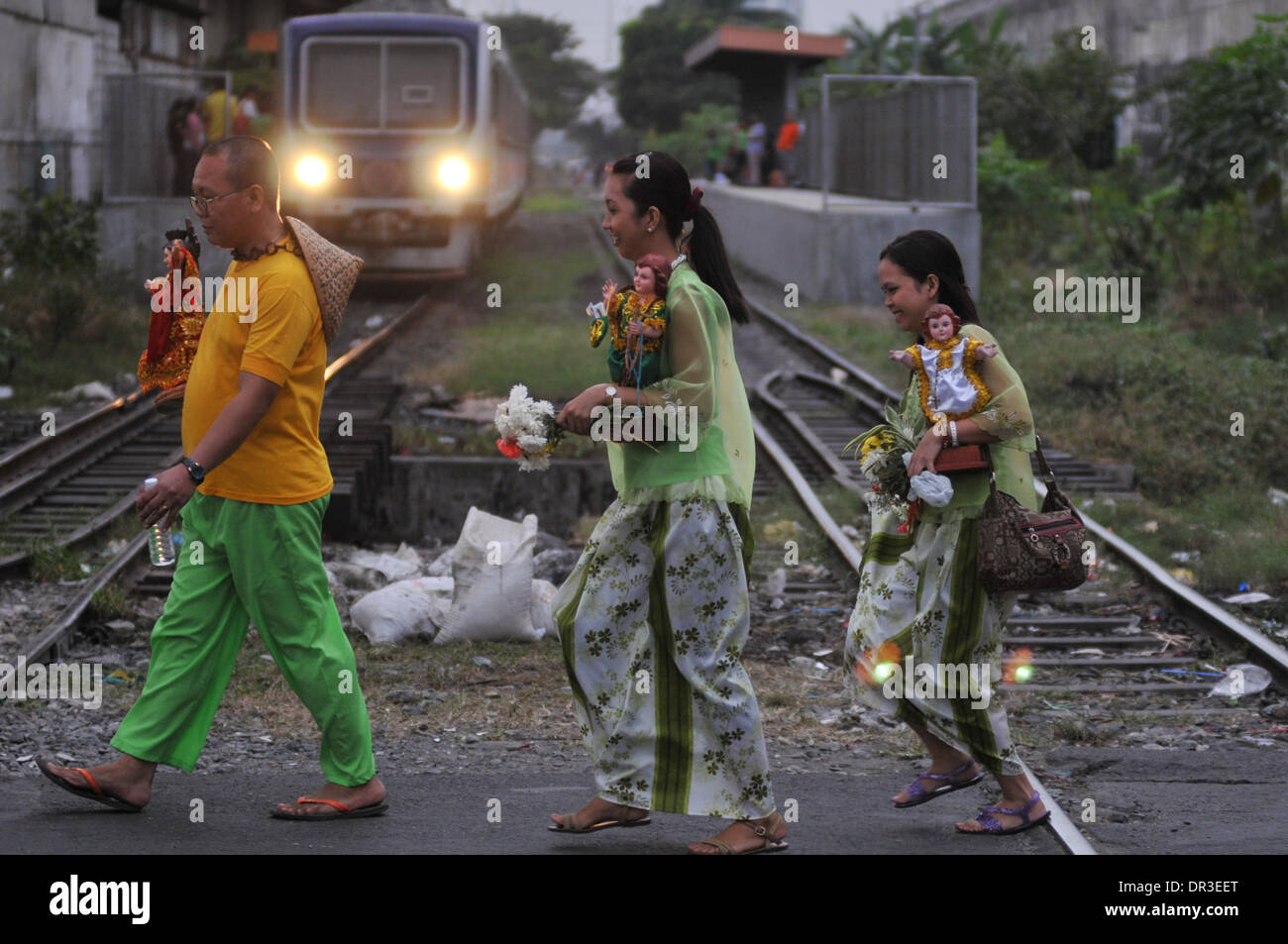 Manila, Filippine. 18 gennaio, 2014. MANILA, Filippine - i Partecipanti attraversare la ferrovia dopo aver preso parte alla street dancing localmente noto come Buling Buling Festival in Pandacan, Manila un giorno prima della festa di sto. Nino, 18 gennaio 2014. La danza tradizionale è tenuto in onore del Sto. Nino che salvò la città di Pandacan dall essere polverizzato mediante gli spagnoli durante il periodo coloniale. Credito: George Calvelo/NurPhoto/ZUMAPRESS.com/Alamy Live News Foto Stock