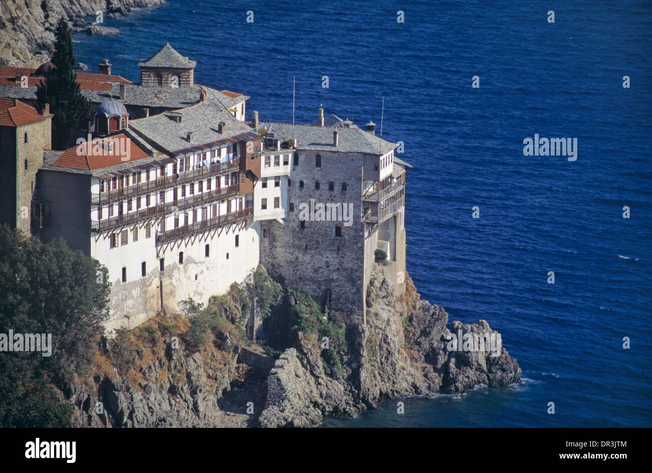 Il Clifftop Osiou Gregoriou monastero (c14th) appollaiato sulla rocciosa costa del Mar Egeo il Monte Athos in Grecia Foto Stock