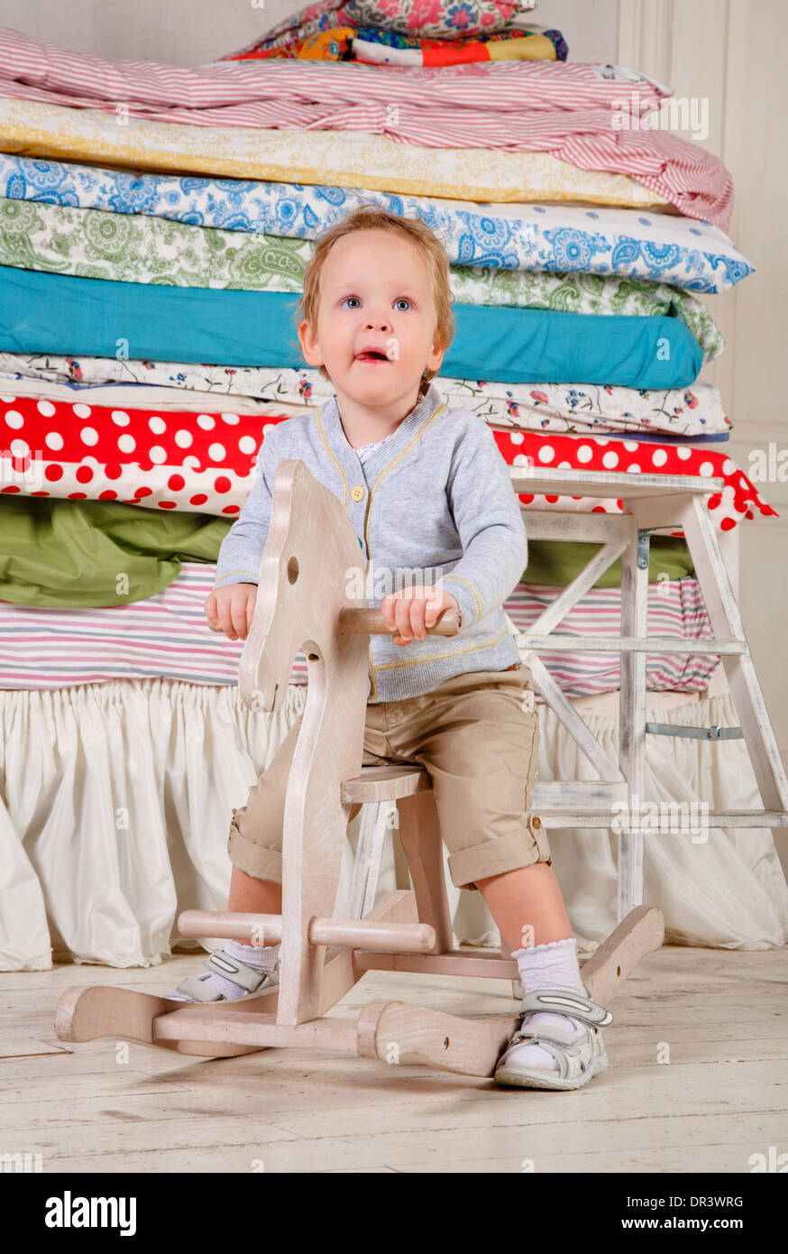 Il bambino gioca con un legno giocattolo a dondolo Pony cavallo. Foto Stock