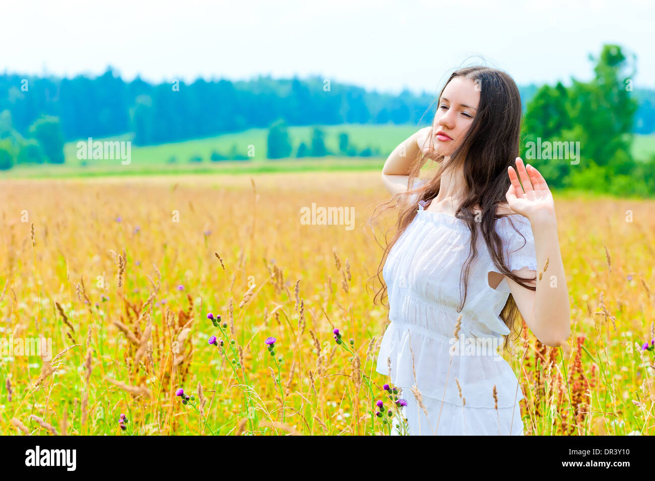 Il russo bella donna in campo con fiori Foto Stock