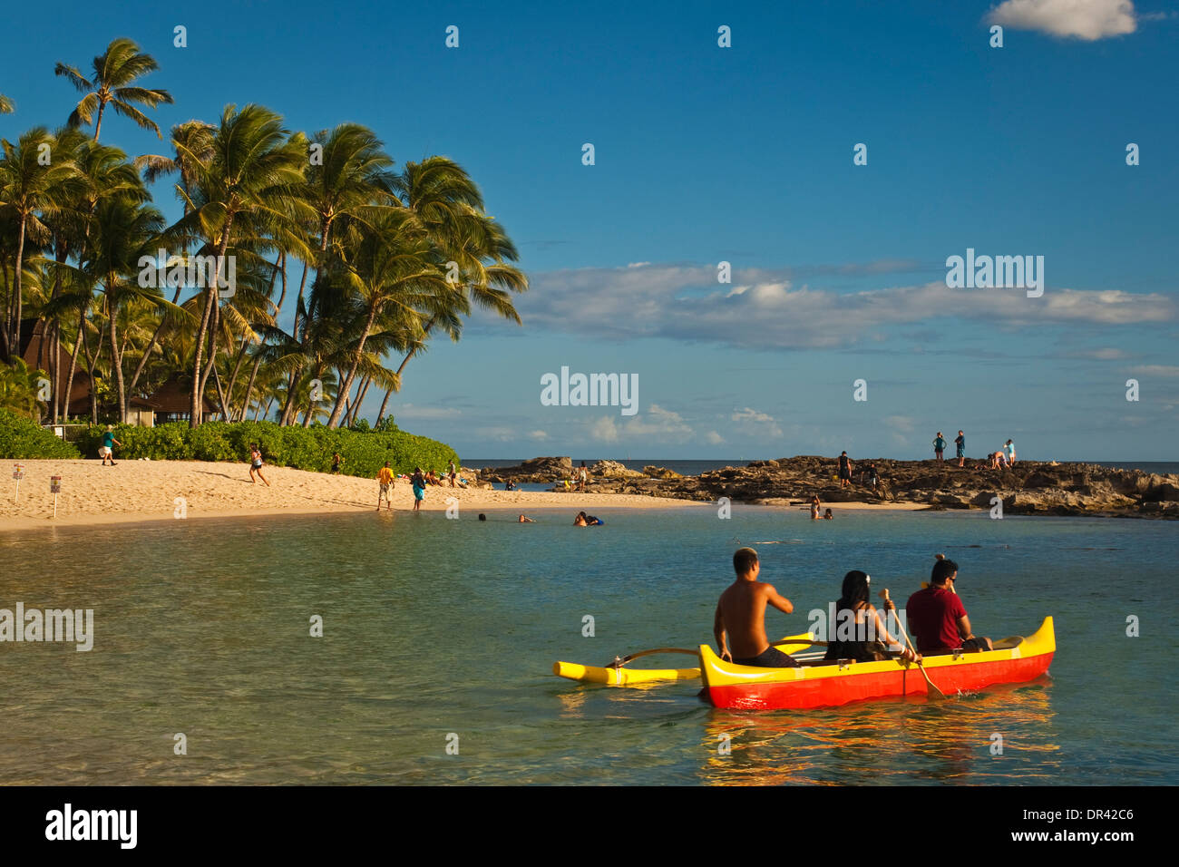 I turisti come ottenere un viaggio in canoa outrigger presso il Paradise Cove Luau, Kapolei, Oahu, Hawaii Foto Stock
