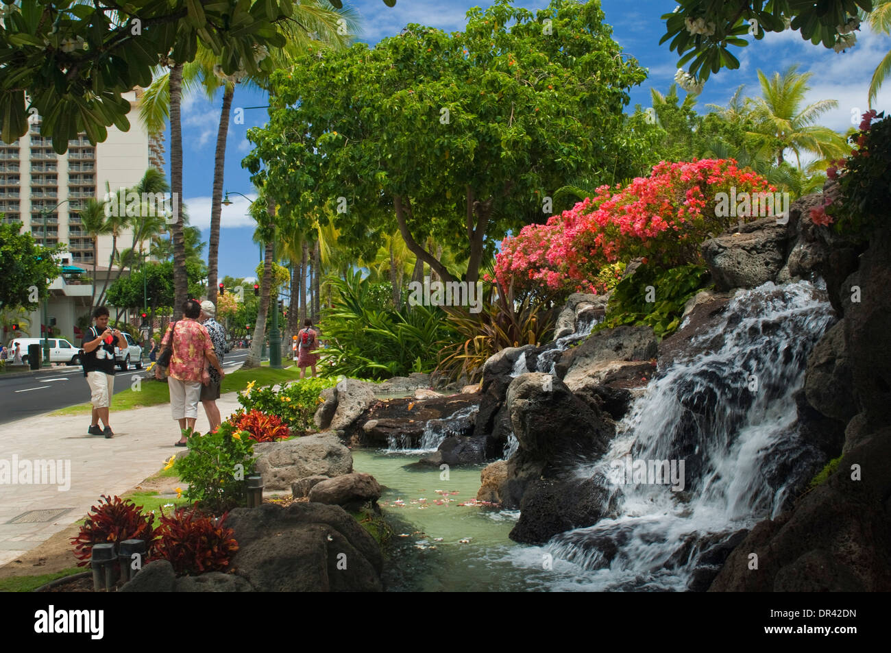 Fiori e fontana a cascata in Kuhio Beach Park, della spiaggia di Waikiki, Honolulu Oahu, Hawaii Foto Stock
