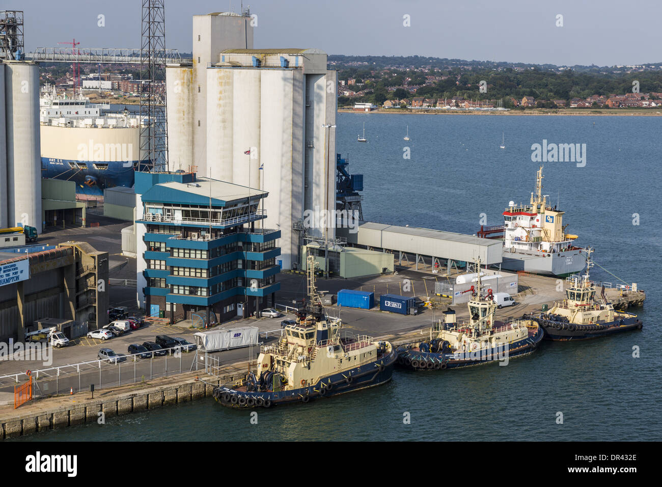 Rimorchiatori a fianco dockhead, Southampton. Home al Porto di Southampton Servizi di assistenza al traffico marittimo nell'edificio blu Foto Stock