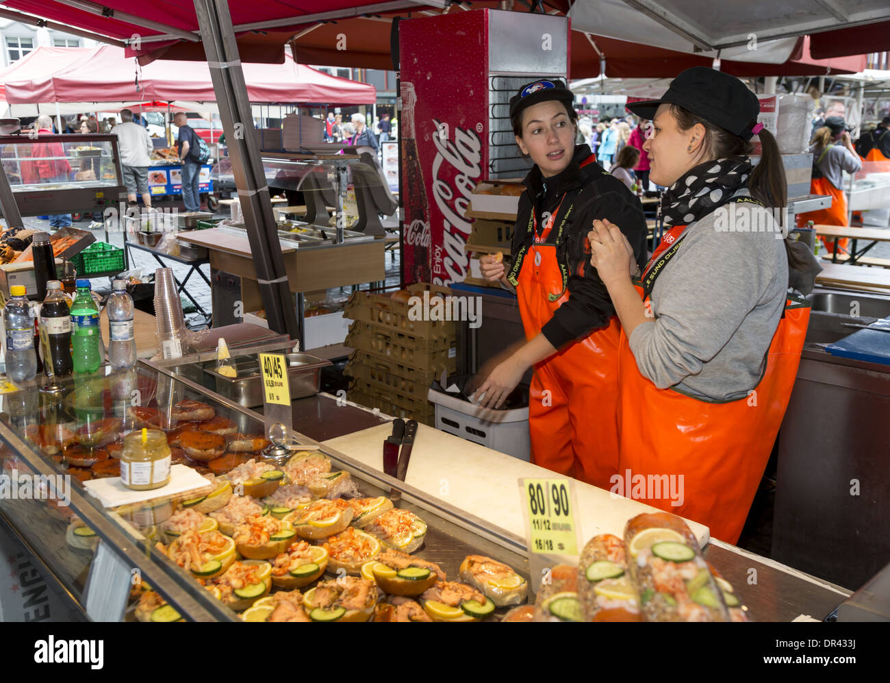 Due donne che la vendita di prodotti a base di pesce su una fase di stallo nel mercato del pesce a Bergen in Norvegia Foto Stock