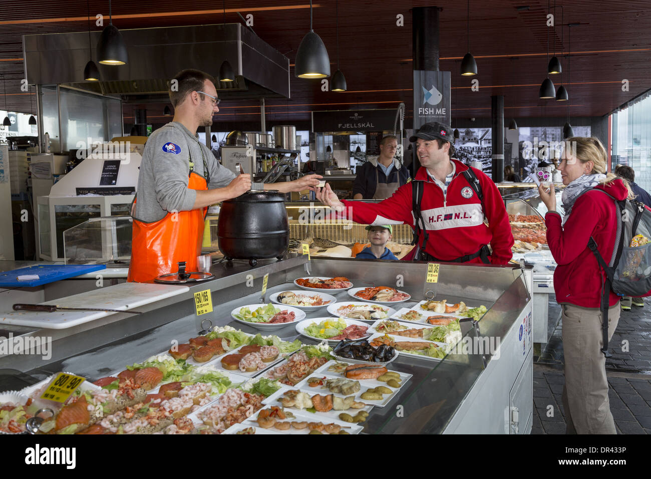 Coppia che prende un campione della zuppa di pesce al Mercato del pesce Bergen Tyskebryggen Norvegia Foto Stock