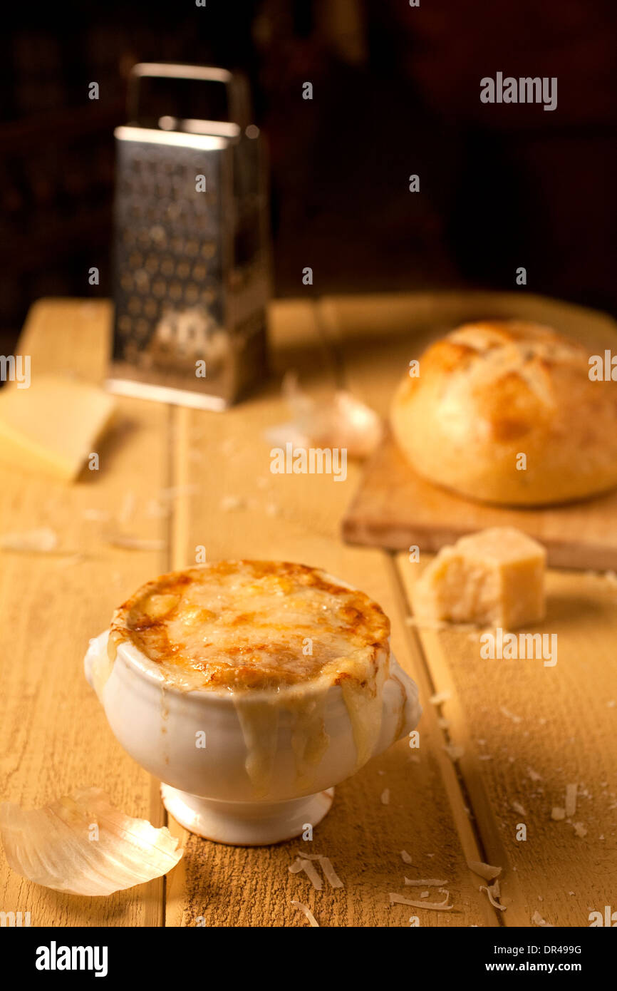 Zuppa di cipolle alla francese con formaggio grattugiato e una pagnotta di pane francese Foto Stock