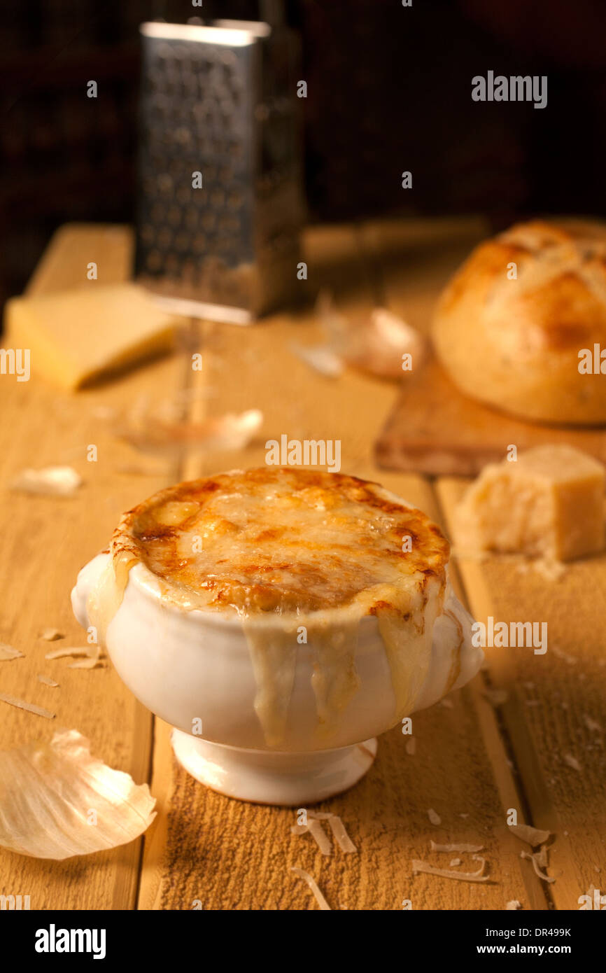 Zuppa di cipolle alla francese con formaggio grattugiato e una pagnotta di pane francese Foto Stock