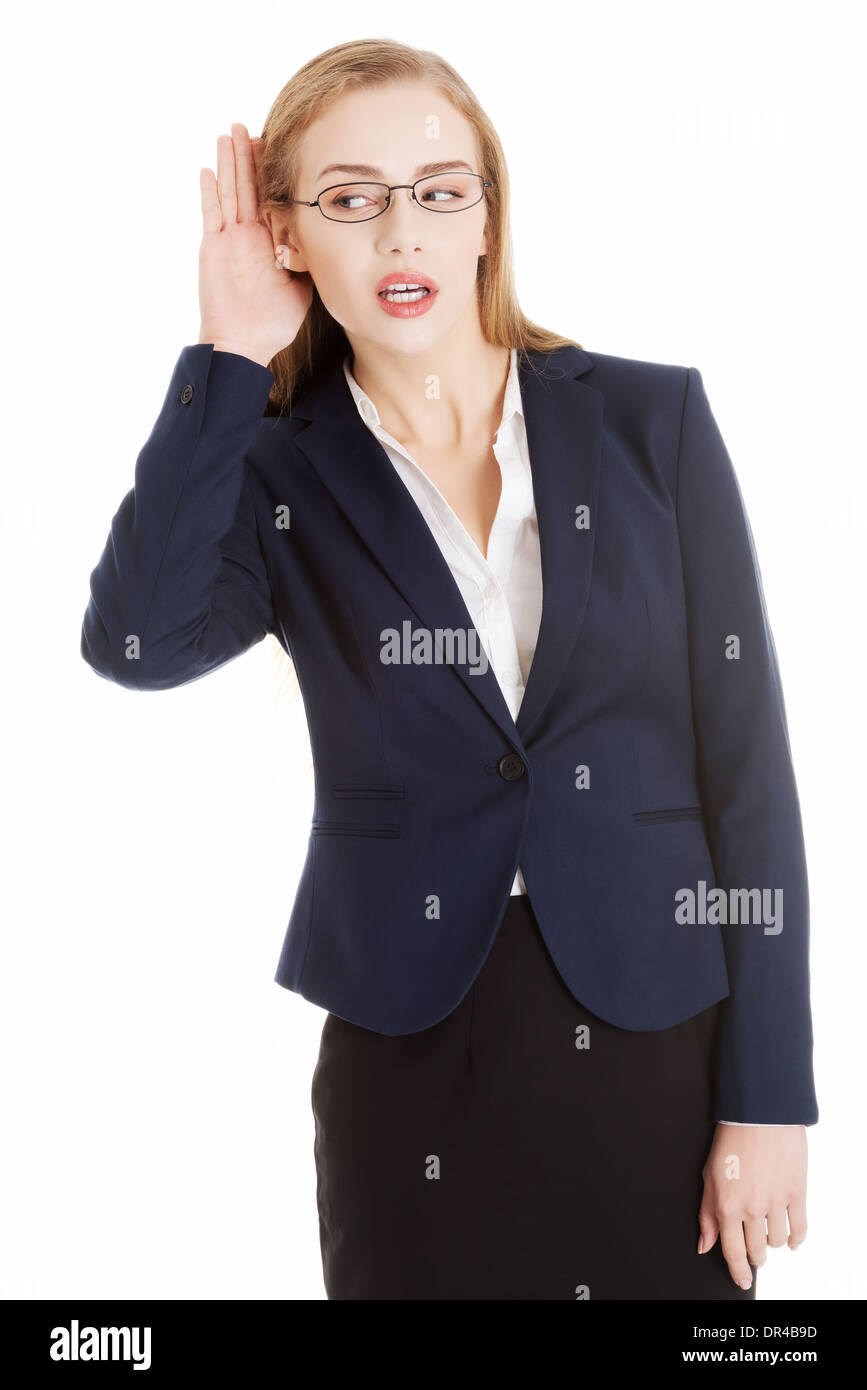 Bella donna d'affari è sovra-AUDIZIONE, trouching il suo orecchio. Isolato su bianco. Foto Stock