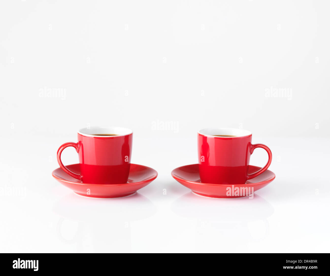 Due rosse piccole tazzine per il caffè isolato su sfondo bianco Foto Stock