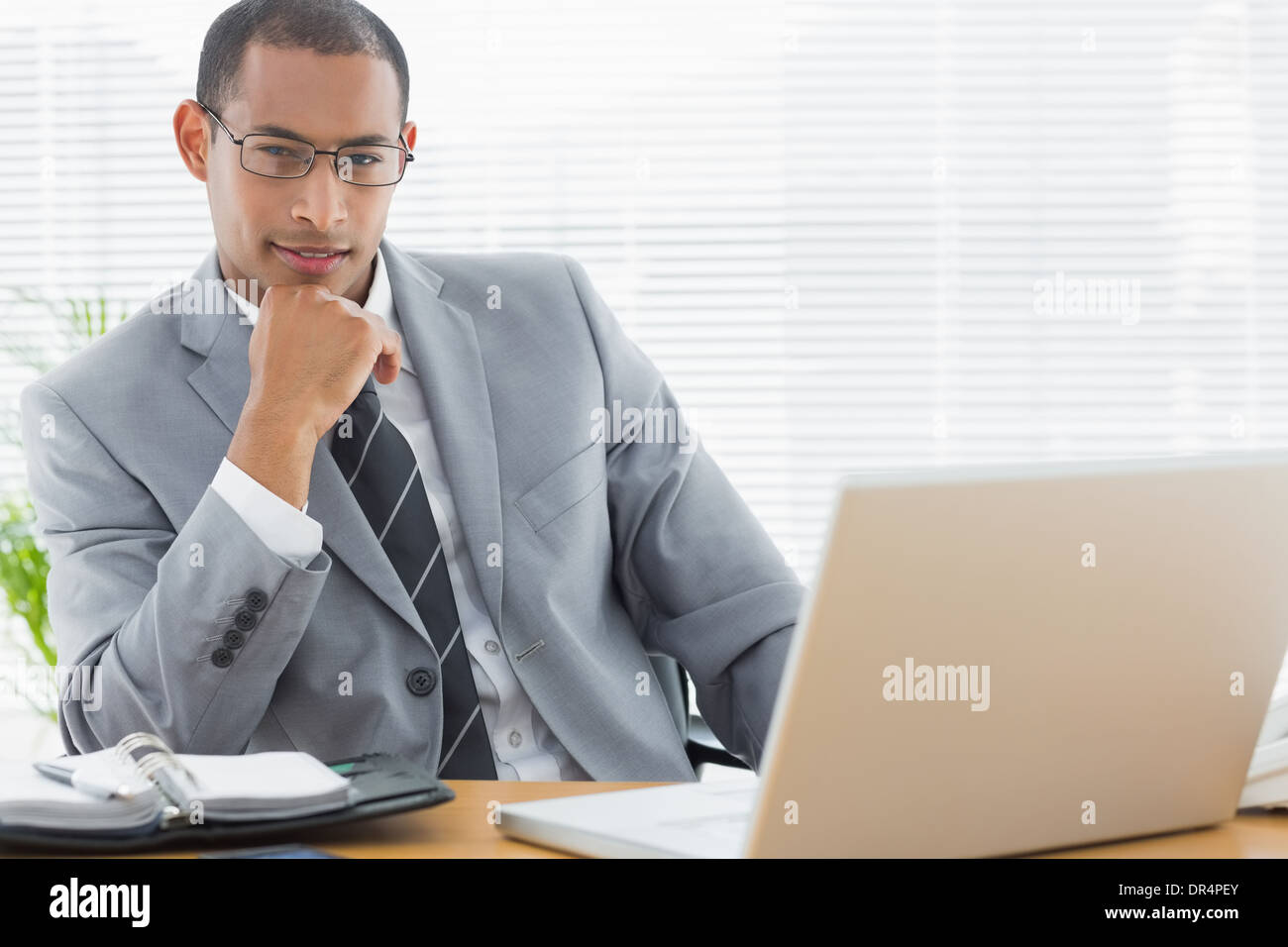 Fiducioso imprenditore con il portatile in ufficio Foto Stock