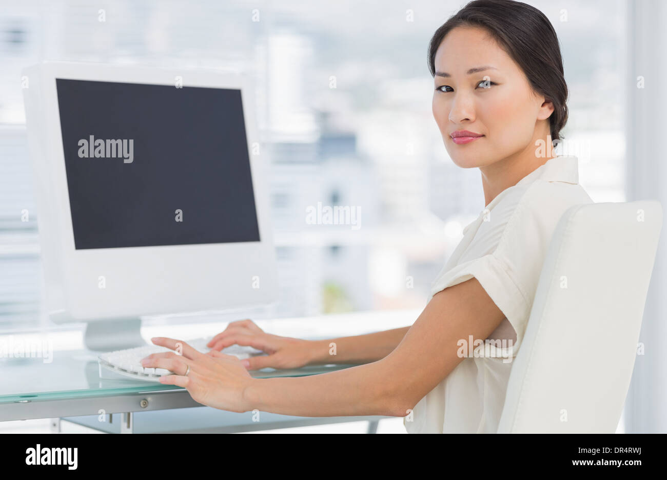 Giovane imprenditrice utilizzando computer in ufficio Foto Stock