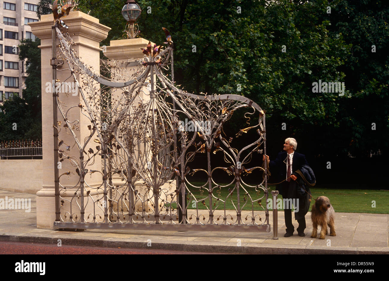 Un passante ammira lavorazione della Regina Madre's Memorial Gates all'entrata occidentale a Hyde Park nel centro di Londra. Foto Stock