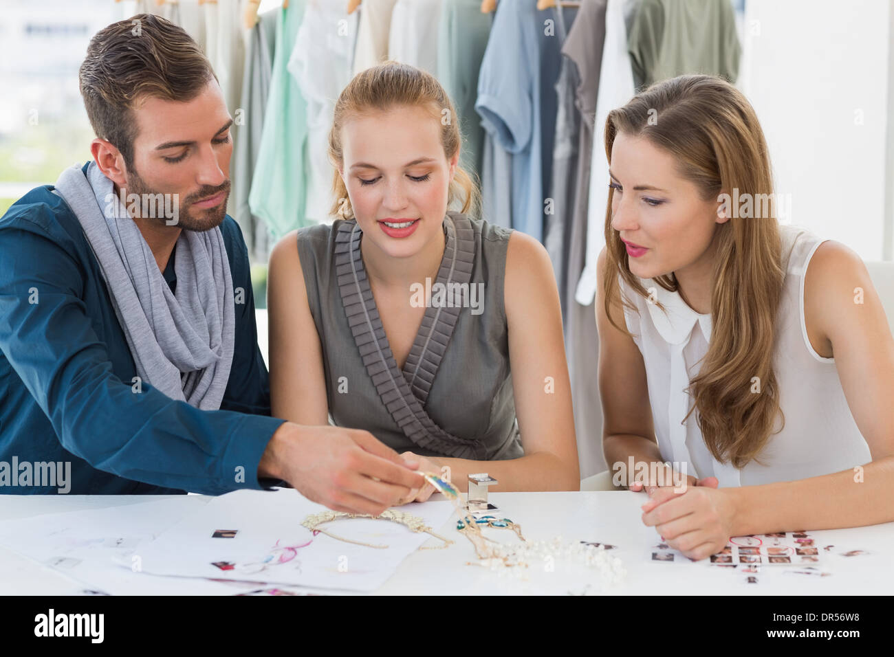 Tre disegnatori di moda a discutere di progetti Foto Stock