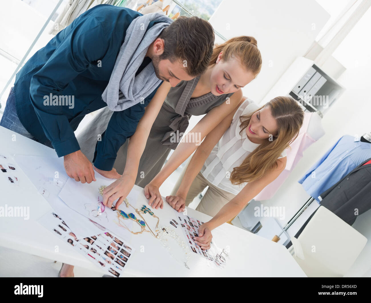 Tre disegnatori di moda a discutere di progetti Foto Stock