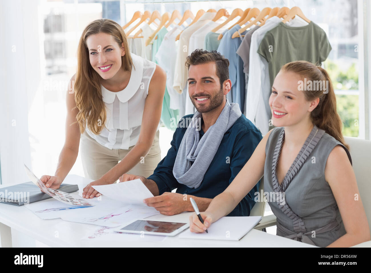 Tre disegnatori di moda a discutere di progetti Foto Stock
