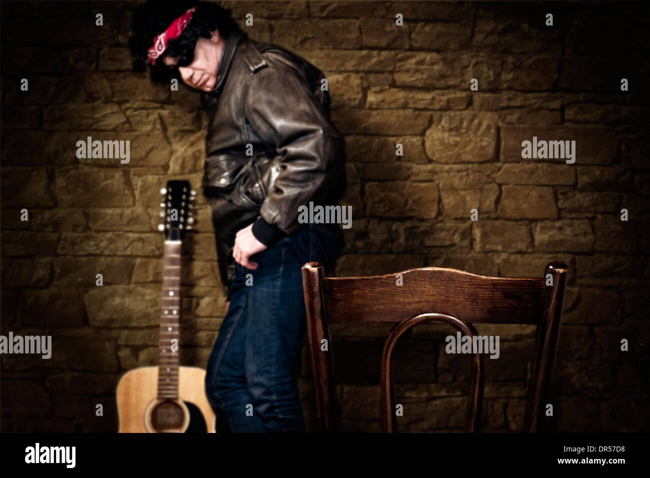 Il musicista si erge contro la parete in profondità di campo Foto Stock
